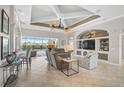 Bright living room featuring tile floors, coffered ceiling, built-in shelving, and sliders to the outdoor pool area at 1662 Bobcat Trl, North Port, FL 34288