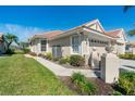 Charming home exterior with lush landscaping, a tile roof, and a well-maintained lawn at 1683 San Silvestro Dr, Venice, FL 34285