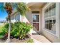 Inviting front entrance with brick pathway, charming landscaping, and a glass storm door at 1683 San Silvestro Dr, Venice, FL 34285