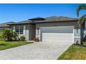 The home has a large driveway, well maintained lawn, and a two-car garage at 16848 Cayo Key Dr, Port Charlotte, FL 33953