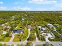 Expansive aerial view of the property showcasing the neighborhood, large lot, mature trees, and charming home at 1785 Bayshore Dr, Englewood, FL 34223