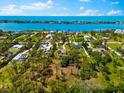Scenic aerial view of the home near the waterfront and charming neighborhood, surrounded by trees and blue skies at 1785 Bayshore Dr, Englewood, FL 34223