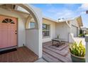 Inviting front porch with arched entry and brick flooring leading to a pink front door at 201 Cavallini Dr, Nokomis, FL 34275
