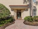 Charming front entrance with a brick walkway, elegant landscaping, and a welcoming wreath on the door at 206 Bella Vista Ter # 29A, Nokomis, FL 34275