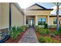 Inviting front entrance with decorative glass door, manicured landscaping, and brick-paved walkway at 20794 Valprato Ct, Venice, FL 34293
