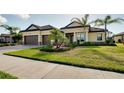 Beautiful property showcasing a tile roof, two-car garage, well-kept lawn, and mature landscaping at 20794 Valprato Ct, Venice, FL 34293