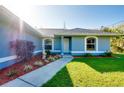 Inviting front entrance with landscaped garden beds and a well-maintained lawn at 3447 Nadasky Ave, North Port, FL 34288