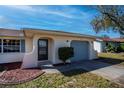 Close up of the front exterior with covered entryway, garage door, and well maintained landscaping at 358 Pineview Dr, Venice, FL 34293