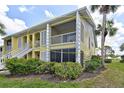 View of condo showcasing the second floor porch, shuttered windows and surrounding foliage at 418 Cerromar Ct # 261, Venice, FL 34293