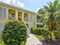 Exterior elevation of the condo, showcasing the second-floor porch and well-maintained grounds at 418 Cerromar Ct # 261, Venice, FL 34293