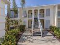 Two-story condo with white exterior, shutters, and a staircase leading to the upper level units at 435 Cerromar Ln # 326, Venice, FL 34293