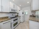 Updated kitchen with white cabinets, granite countertops, and stainless steel appliances at 435 Cerromar Ln # 326, Venice, FL 34293