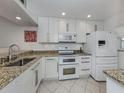 Bright kitchen featuring granite countertops, modern white cabinetry, and stainless steel appliances at 435 Cerromar Ln # 326, Venice, FL 34293