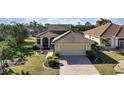 Charming single-story home with a well-maintained lawn and a two-car garage, set in a tranquil, lush community at 456 Pinewood Lake Dr, Venice, FL 34285