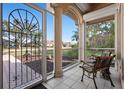 Inviting front porch with tile flooring and decorative metal door, providing a charming entrance to the home at 456 Pinewood Lake Dr, Venice, FL 34285