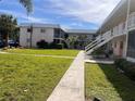 The building's exterior features well-maintained landscaping and a long walkway to the units at 460 Base E Ave # 129, Venice, FL 34285