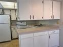 A bright kitchen with white cabinetry, countertops, and appliances at 460 Base E Ave # 129, Venice, FL 34285