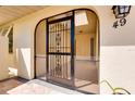 Inviting front entrance featuring a security gate with decorative wrought iron and tiled entryway at 49 Sandstone Cir, Venice, FL 34293