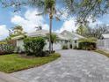 Charming one-story home featuring a brick paved driveway, lush landscaping, and an attached two-car garage at 503 Clubside Cir # 47, Venice, FL 34293