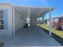 Attached carport providing covered parking and protection from the elements, next to a well maintained lawn at 508 Vasto Dr, Venice, FL 34285