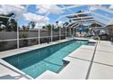 Sparkling pool with screened enclosure, patio furniture, and ample space for entertaining at 509 Alhambra Rd, Venice, FL 34285