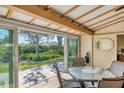 Bright, airy porch with exposed beams, sliding doors, and views of the landscaped backyard at 51 Oakwood N Dr # 51, Englewood, FL 34223