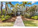 Stunning two-story home with lush landscaping and a brick walkway leading to the front door at 524 Lyons Bay Rd, Nokomis, FL 34275