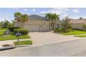 Charming home with a three-car garage, brick paved driveway, and lush landscaping at 5550 Rock Dove Dr, Sarasota, FL 34241