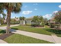 Lovely single-story home with well-maintained landscaping, palm trees, and a paved driveway at 614 Pond Willow Ln, Venice, FL 34292
