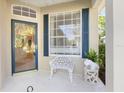 Close-up of front porch featuring blue door and shutters with decorative bench and elephant sculpture at 915 Tartan Dr # 29, Venice, FL 34293