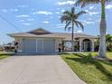 Charming single-story home featuring a two-car garage, arched entry, and well-manicured lawn at 9542 Spring Cir, Port Charlotte, FL 33981