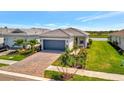 Desirable single-Gathering home with a paver driveway, a gray tile roof, and manicured landscaping at 10399 Abaco Falls Dr, Englewood, FL 34223