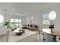 Bright and airy living room featuring modern furnishings, neutral tones, and a sliding glass door at 10399 Abaco Falls Dr, Englewood, FL 34223