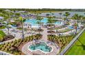 Resort-style community pool featuring multiple swimming areas, lounge chairs, and tropical landscaping at 10399 Abaco Falls Dr, Englewood, FL 34223