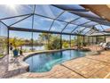 A screened-in pool area features a relaxing spa and views of the serene waterfront at 10139 Kansas City St, Port Charlotte, FL 33981