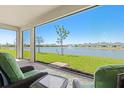 View from the tiled outdoor patio, overlooking a lush green yard, large pond and other homes at 1606 Cedar Valley Dr, Port Charlotte, FL 33953
