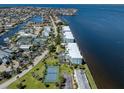 Aerial view of waterfront condominium buildings, tennis courts, and surrounding neighborhood near the bay at 1750 Jamaica Way # 322, Punta Gorda, FL 33950