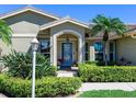 Charming home with a blue front door framed by lush landscaping and a manicured lawn at 1763 Cartina Way, Venice, FL 34292