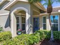 Welcoming front porch featuring a blue door, potted plants, and ample natural light at 1763 Cartina Way, Venice, FL 34292
