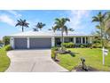 Beautiful single Gathering home featuring a two car garage, mature landscaping and pristine lawn at 18382 Arapahoe Cir, Port Charlotte, FL 33948