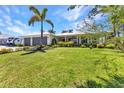 Inviting one-story home with a well-manicured lawn, lush landscaping and two car garage at 18382 Arapahoe Cir, Port Charlotte, FL 33948