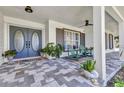 Charming front porch featuring stylish tile flooring, comfortable seating, and elegant double doors at 18382 Arapahoe Cir, Port Charlotte, FL 33948