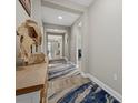 Hallway with neutral paint, tile flooring, and decorative table at 19800 Montenero Way, Venice, FL 34293