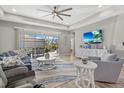 Bright living room with sliding glass doors to the outdoor pool and ceiling fan at 19800 Montenero Way, Venice, FL 34293