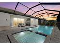 Inviting screened-in pool and spa with outdoor dining and grill area at 19800 Montenero Way, Venice, FL 34293