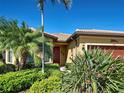 Beautiful single-story home featuring lush landscaping, including palm trees and bird of paradise at 19911 Quisto St, Venice, FL 34293