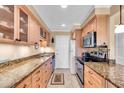 Efficient kitchen features granite countertops, wooden cabinets, and modern stainless steel appliances at 200 The Esplanade N # B3, Venice, FL 34285