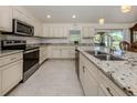 Modern kitchen features white cabinets, stainless steel appliances, and granite countertops at 2098 Zellwood Ter, North Port, FL 34286