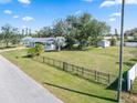 Charming home with a spacious front yard, mature trees, a fence, and a storage shed at 2102 Alaric St, Port Charlotte, FL 33952