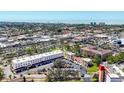 Aerial view showcasing the real estate's surroundings, including trees, parking, and the ocean at 238 Tampa W Ave # 217, Venice, FL 34285